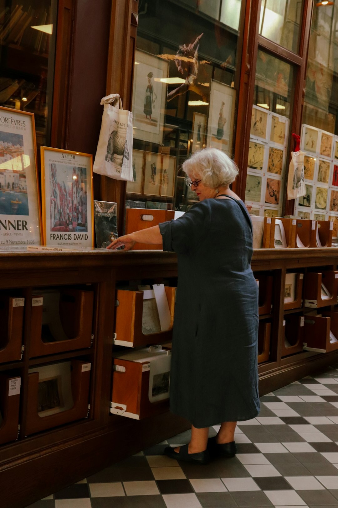 Swiss woman archivist examining vintage advertising posters